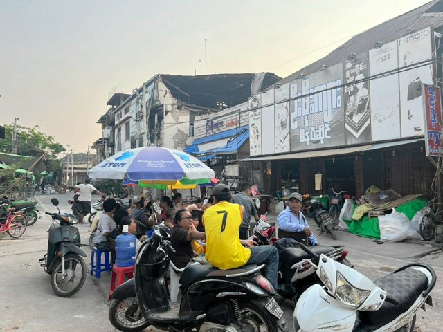 ミャンマーの首都ネピドー郊外ピンマナーで2025年3月29日、地震で損壊した建物を前に、路上に避難した人たち。ここで野宿しているという=笠原真撮影